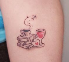 a tattoo on the leg of a woman with a glass of wine and books