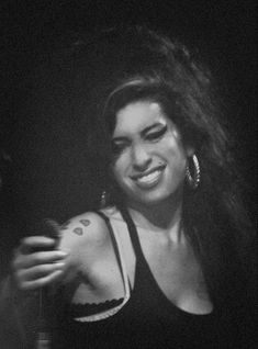 black and white photograph of a woman smiling with her hair blowing in the wind at night