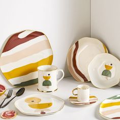 a table topped with plates and cups filled with food next to utensils on top of a counter