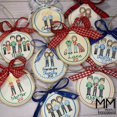 some cookies decorated to look like family members are hanging on a table with ribbon around them