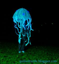 a man is dressed as a jellyfish in the dark