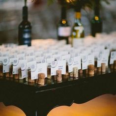 there are many wine bottles and place cards on the table for guests to sit at