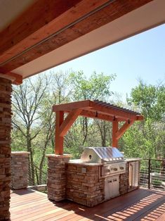 an outdoor kitchen with grill and covered patio