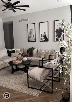 a living room filled with furniture and pictures on the wall