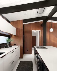 Wood, white, and black served as the clean palette for the new design of this  kitchen in a renovated mid-century modern home. Eichler Kitchen, Teal Kitchen Cabinets, Mid Century Modern Kitchen Design, Kitchen Design Black, Brick Accent Walls, Modern Kitchen Design Black, Teal Kitchen, Eichler Homes, Black Kitchen Island