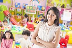 a woman standing with her arms crossed in a children's play room full of toys