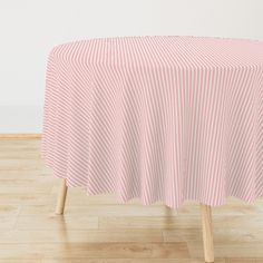 a pink and white striped table cloth sitting on top of a wooden chair in front of a wall