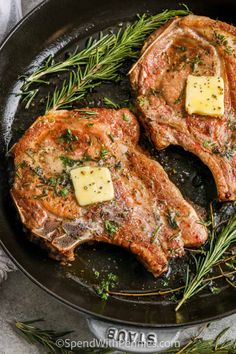 two steaks in a skillet with butter and rosemary sprigs on the side