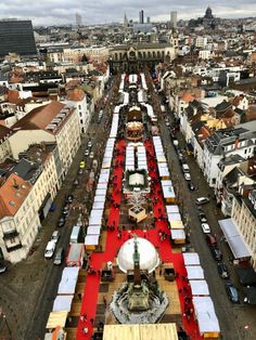 an aerial view of a city with many tables and benches set up in the center