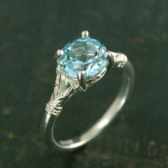 an engagement ring with a blue topazte stone