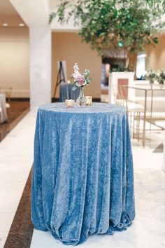 a blue table cloth on top of a round table