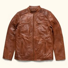 The Thompson Leather Moto Jacket is made from 100% Lambskin Leather. This luxurious material is soft like a worn-in-jacket, and the quilted lining makes putting it on or taking it off a breeze. An interior chest pocket securely holds a journal or phone, and four exterior zippered pockets are designed for your keys or wallet. This lambskin leather jacket in our Whiskey Tan color is finished with zippered cuffs and an antique brass zipper finishing. For sizing, the fit is slightly small and we rec Vintage Leather Motorcycle Jacket, Cafe Racer Leather Jacket, Brown Cafe, Cafe Racer Design, Vintage Cafe Racer, Motorbike Jackets, Cafe Racer Style, Cafe Racer Jacket, Racer Jacket