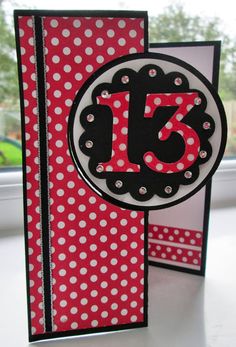 a close up of a card on a window sill with polka dots and the number thirteen