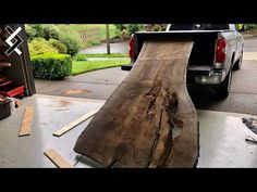 a large piece of wood sitting on top of a wooden table next to a truck