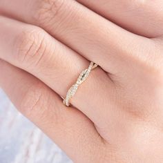 a woman's hand with a diamond ring on her left hand, wearing a white and yellow gold band