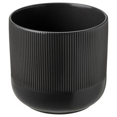 a black vase is sitting on a white surface and it has pleated lines in the center