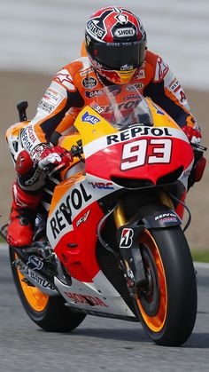 a man riding on the back of a motorcycle down a race track