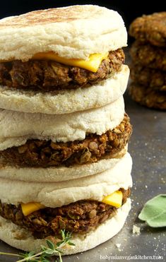 three sandwiches stacked on top of each other with cheese and meat in between the buns