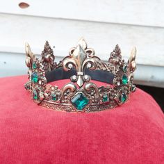 a tiara is sitting on top of a red cushion