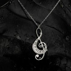 Elevate your ensemble with the timeless elegance of the Sussex Home Treble Clef Necklace. This exquisite piece is meticulously handcrafted from sterling silver and adorned with a lustrous gold plating, making it a stunning choice for any music enthusiast.

- Material: Sterling Silver, Gold Plated
- Color: Gold
- Gender: Female
- Age Group: Adult

Designed with a delicate treble clef pendant, this necklace serves as a symbol of your everlasting love for music. It's the perfect gift for bridesmaid Nickel-free Silver Music-themed Necklaces, Silver Music-themed Necklace For Gift, Music-themed Silver Pendant Necklace, Music-themed Metal Jewelry For Gifts, Silver Sterling Music-themed Necklace, Nickel-free Sterling Silver Music-themed Necklace, Music-themed Sterling Silver Necklace, Silver Music-themed Metal Necklace, Silver Music-themed Metal Jewelry