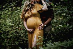 a pregnant woman in a yellow dress standing next to a man