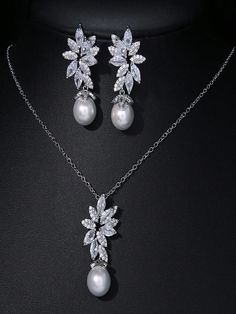 a necklace and earring set with pearls on a black background, the jewelry is decorated with crystal leaves