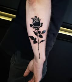 a black rose tattoo on the left arm