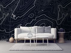 a white couch sitting on top of a rug next to a wall covered in black and white lines