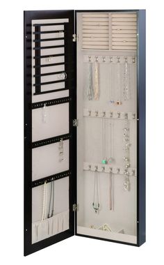 an open jewelry cabinet with many necklaces and bracelets hanging on the doors,