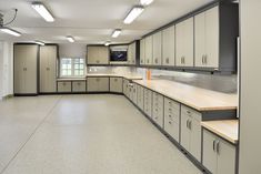 an empty kitchen with lots of counter tops and cupboards on the walls, along with lights