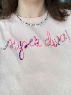 a close up of a person wearing a sweater with the word super dud on it