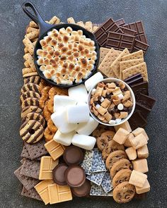 a platter filled with crackers, marshmallows, and other snacks