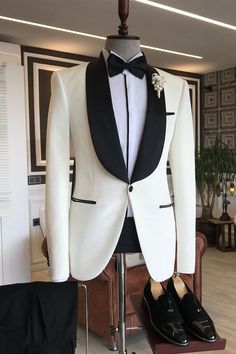 a white tuxedo with black lapel collar and bow tie is on display