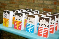 several bags with different designs on them sitting on a blue table in front of a brick wall