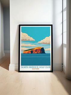 a framed poster is sitting on the floor in front of a wall with a window