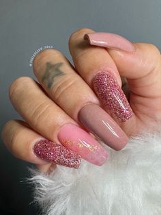 a person with pink and gold nail polish on their nails, holding up her hand