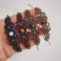 three pieces of beaded fabric are held in someone's hand