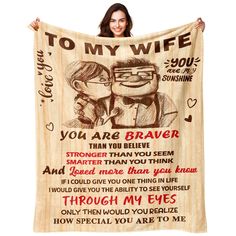 a woman holding up a blanket with the words to my wife