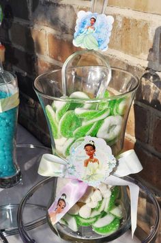 a glass vase filled with green and white candies on top of a metal stand