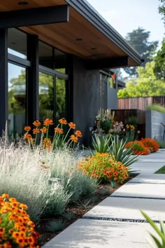 an outside view of a house with flowers and plants