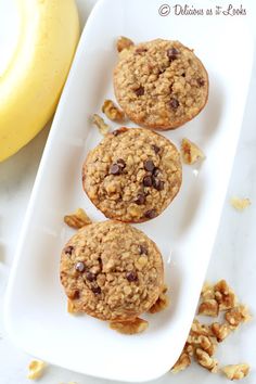 three chocolate chip oatmeal muffins on a white plate next to a banana