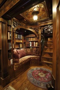 a room that has some bookshelves and a couch in it with a rug on the floor