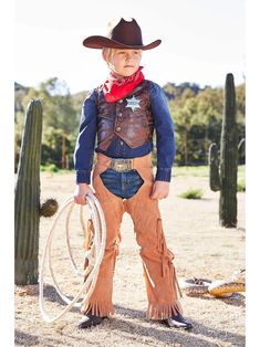 a little boy dressed up as a cowboy holding a lasso