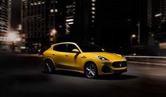 a yellow sports car driving through the city at night