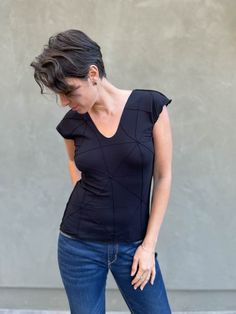 Our summer t-shirt alternative, made from our textured jersey, this top is stretchy and easy. The scoop neck is mirrored on the back and the length hits just below the waistline. Black Cotton Racerback Muscle Tee, Casual Moisture-wicking Racerback Muscle Tee, Sporty Moisture-wicking Racerback Muscle Tee, Fitted Sleeveless Top With Cutout Details, Cotton Moisture-wicking Sleeveless Muscle Tee, Natural Curves, Draped Fabric, Jersey Top, Summer Tshirts