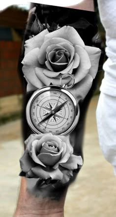 a man's arm with three roses and a compass on it