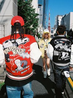 three people walking down the street wearing jackets with dreadlocks on their heads and back