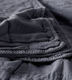 an unmade bed is shown with dark blue sheets