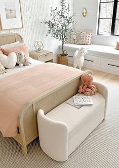 a bed room with a neatly made bed and two stuffed animals on the foot board