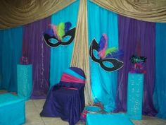 a room decorated in blue, purple and green with masks on the wall for masquerade